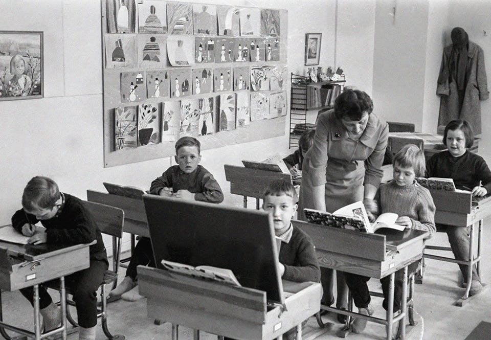 Barn och lärarinna i ett klassrum